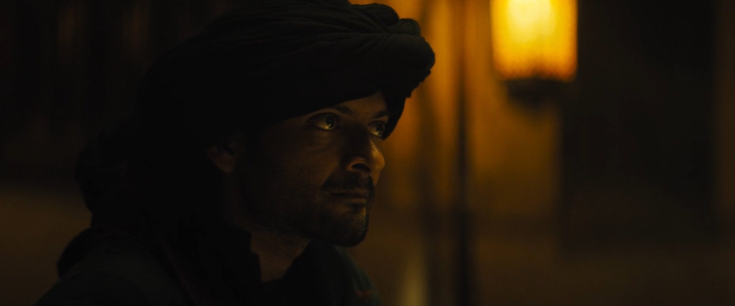 A man in a turban by lamplight