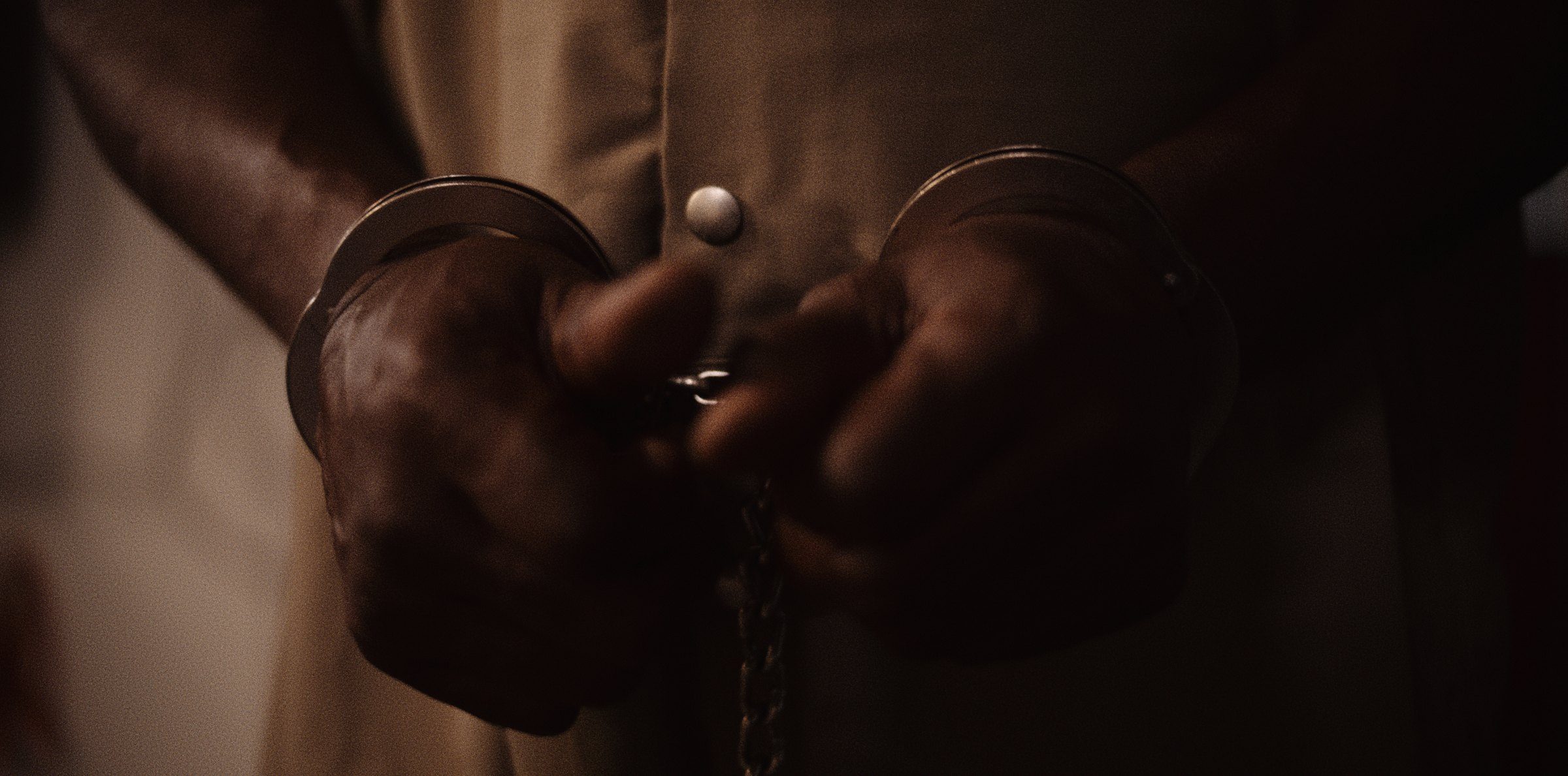 Handcuffed hands held at the waist
