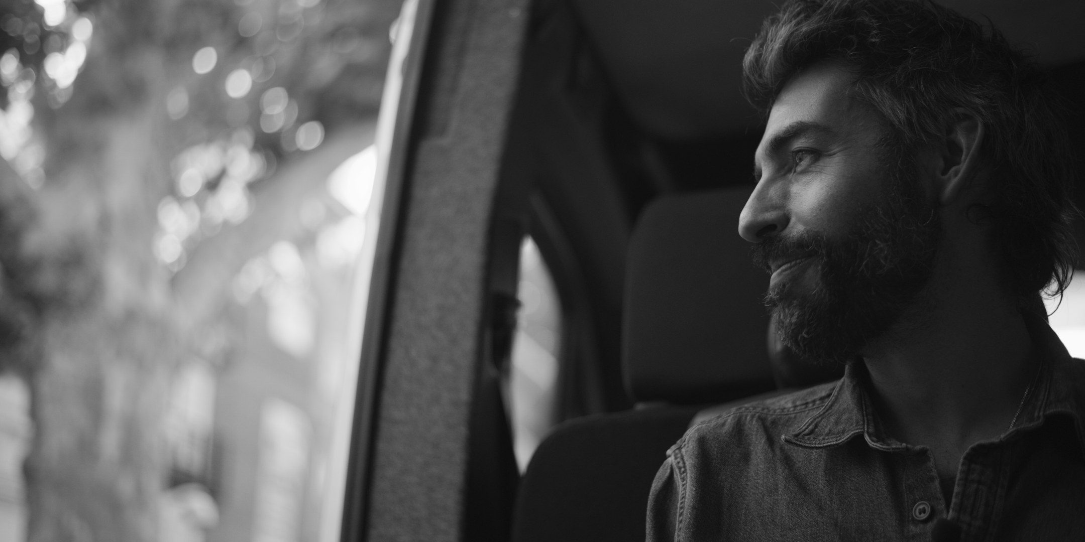 Leif Vollebekk smiling out of a van window