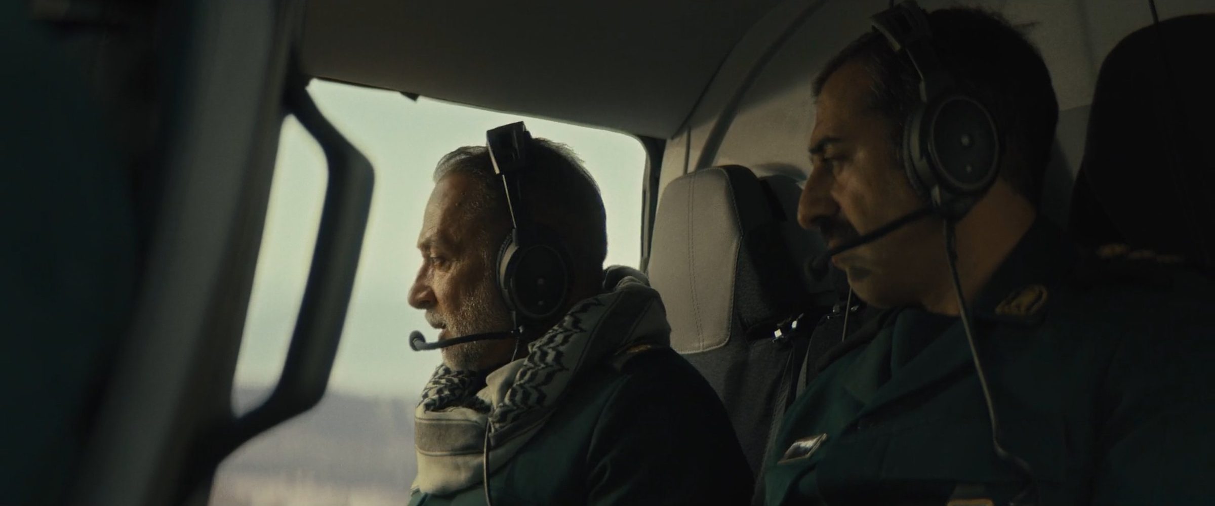 Two men in headsets in a helicopter cockpit