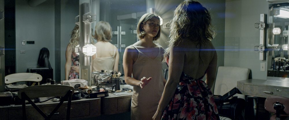 Two women facing each other in a mirrored dressing room